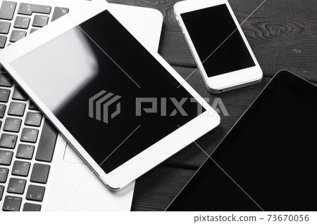 Open laptop with digital tablet and smartphone close up Open laptop with digital tablet and smartphone close up 73670056