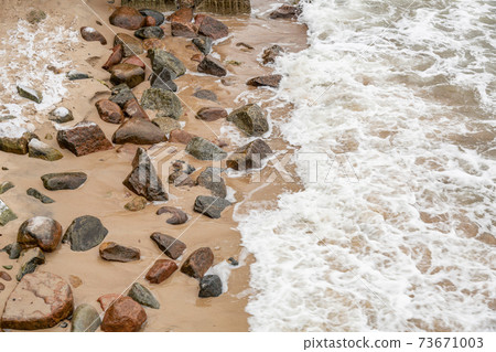 Large stones and sea waves on the beach Large stones and sea waves on the beach 73671003