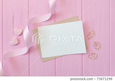 Wedding or birthday mock up scene. Blank open envelope with place for text for greeting card copyspace. Valentines card with two hearts on pink background. Flat lay, top view Wedding or birthday mock up scene. Blank open envelope with place for text for greeting card copyspace. Valentines card with two hearts on pink background. Flat lay, top view 73671299