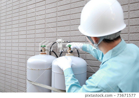 Workers inspecting propane gas cylinders Workers inspecting propane gas cylinders 73671577