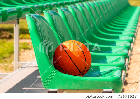 Stadium chairs with an orange basketball 73671628