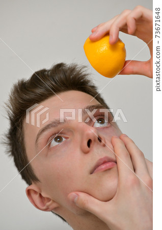 Man Putting Lemon Fruits Drops In His Eye 73671648