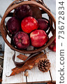 Harvest of red apples in wooden basket in autumn season, fresh organic fruits 73672834