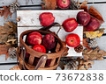 Top view of Autumn setup with fresh red apples and natural leaves, festive background 73672838