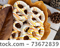 Closeup of glazed pretzels on the plate with autumn leaves on wooden background, season holiday concept 73672839