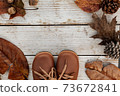 Autumn background with brown shoes and natural leaves on wooden table, seasonal pattern as mockup or banner 73672841