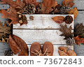 Autumn background with brown leather shoes and natural leaves on wooden table 73672843