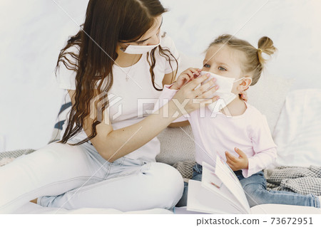 Mother and baby at home with medical masks Mother and baby at home with medical masks 73672951