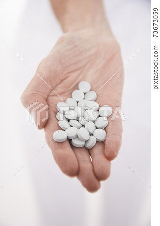 Hand Holding Out Many Pills Hand Holding Out Many Pills 73673059