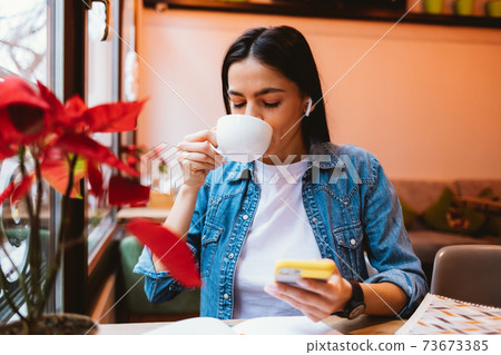 Young woman holding a mug with a drink 73673385