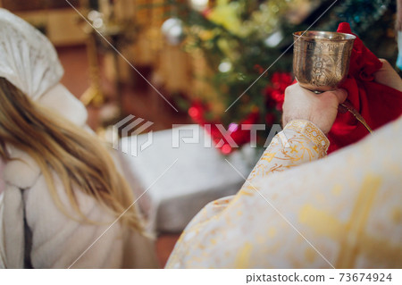 Water is poured into the font for bathing the baby in the church, religious traditions. 73674924