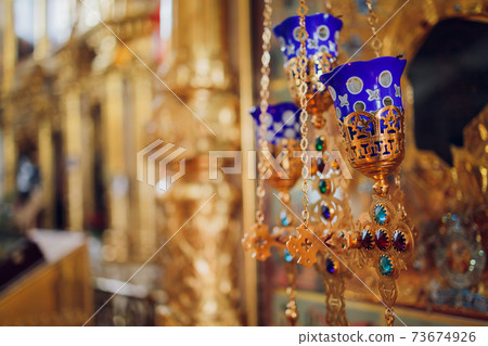 Lighting candles in a catholic temple . Candles are lit near the altar in a Catholic temple. 73674926