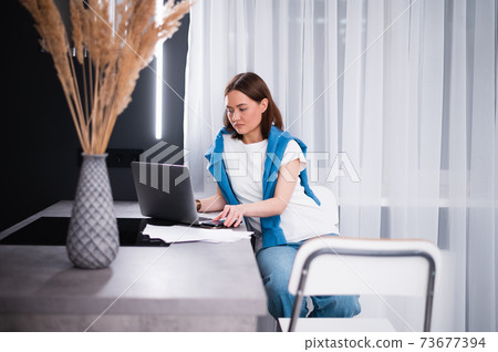 Portrait of gamer girl playing online game on a laptop from home 73677394