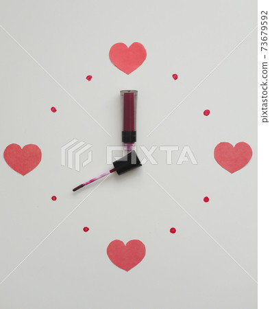 Clock face and arrows on a white background made from cosmetic products for make-up, lipstick and brush. Flat lay top view. Saint Valentine's day, Women's day concept Clock face and arrows on a white background made from cosmetic products for make-up, lipstick and brush. Flat lay top view. Saint Valentine's day, Women's day concept 73679592