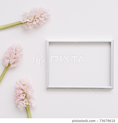 Wedding or birthday flat lay composition with pink flowers and blank photo frame, mockup, invitations. top view, copy space.  73679618