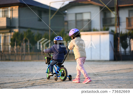Brothers practicing bicycles 73682669