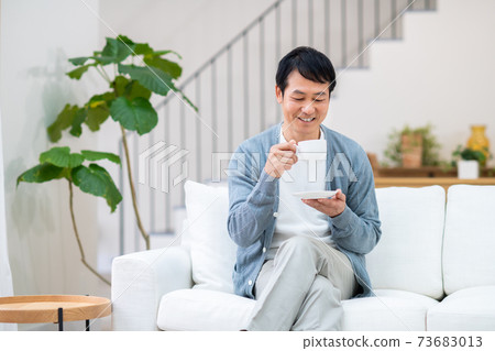中間人在客廳裡喝咖啡 73683013