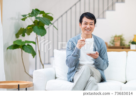 中間人在客廳裡喝咖啡 73683014