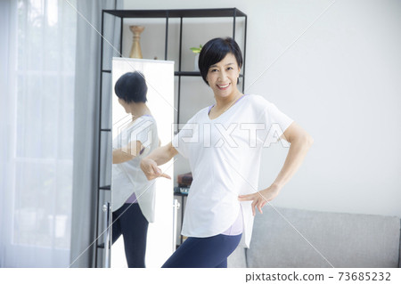 一個五十多歲的女人,看著她檢查自己的比例 一個五十多歲的女人,看著她檢查自己的比例 73685232