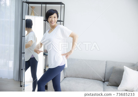 一個五十多歲的女人,看著她檢查自己的比例 一個五十多歲的女人,看著她檢查自己的比例 73685233