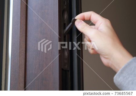 A male hand that opens and closes the key to the parent-child door at the entrance 73685567