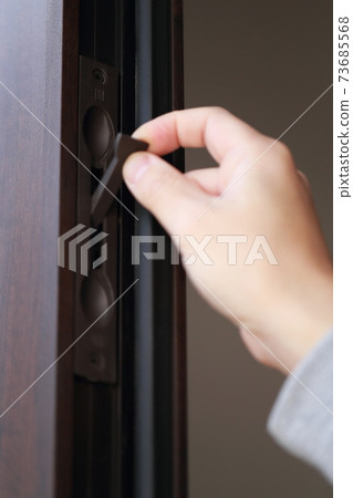 A male hand that opens and closes the key to the parent-child door at the entrance 73685568