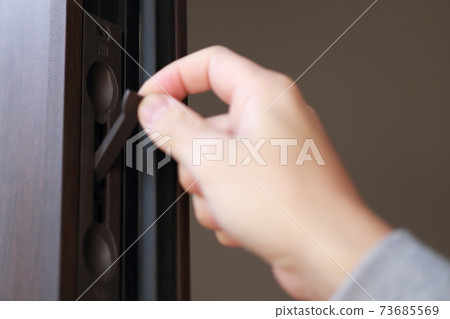 A male hand that opens and closes the key to the parent-child door at the entrance 73685569