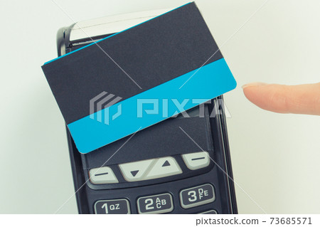 Hand showing credit card reader with contactless credit card. Cashless paying for different things 73685571