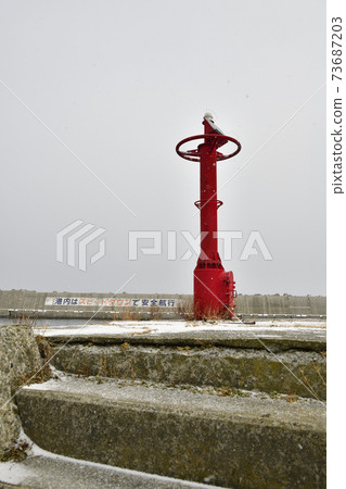 Photographing the snow scene of the lighthouse at Usujiri Fishing Port in Hakodate City, Hokkaido in winter 73687203