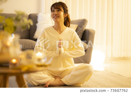 Woman doing yoga in the living room at night 73687762