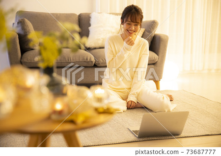 Woman doing yoga in the living room at night 73687777
