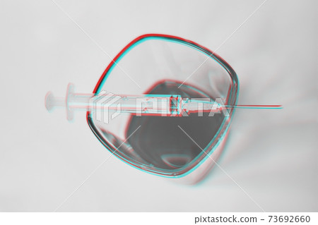 A glass of whiskey and a syringe on it as a concept with drugs and the effect of black and white photography is a glitch effect. A glass of whiskey and a syringe on it as a concept with drugs and the effect of black and white photography is a glitch effect. 73692660