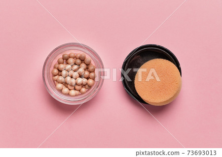 Cosmetic powder in the form of balls on a pink background. Top view. 73693013
