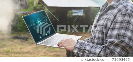 Agriculture technology attractive farmer navigating farmland with laptop computer  innovations for increasing productivity in agriculture. 73693465