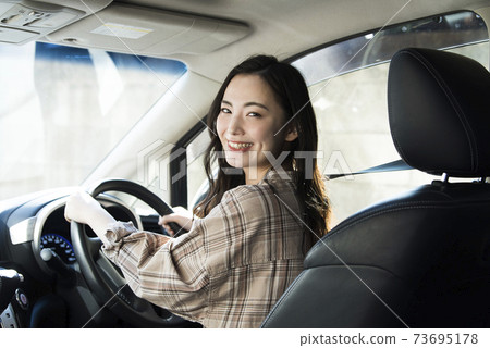 A young woman driving a car 73695178