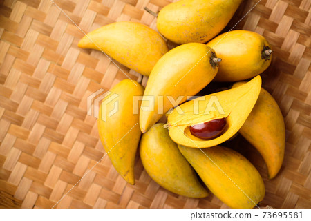 Eggfruit or canistel on bamboo tray, Top view Eggfruit or canistel on bamboo tray, Top view 73695581