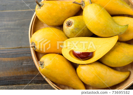 Eggfruit or canistel in a bamboo tray, Top view Eggfruit or canistel in a bamboo tray, Top view 73695582