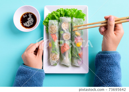 Fresh vegetables spring roll eating with soy sauce 73695642