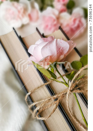 Roses and old books. Retro photo. Vintage photo 73696144