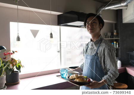 Man making breakfast in the kitchen Man making breakfast in the kitchen 73699348