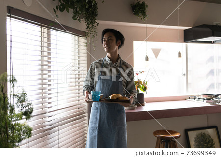 Man making breakfast in the kitchen Man making breakfast in the kitchen 73699349