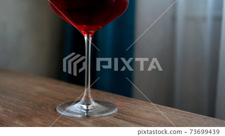 Long stem wine glass with red wine Long stem wine glass with red wine 73699439