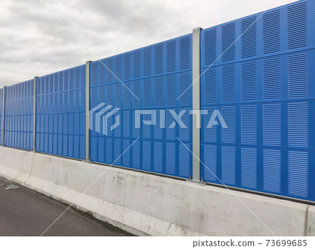 SELANGOR, MALAYSIA - JULY 2, 2020: Noise barriers are installed along the vehicle lane bordering the residence to prevent noise pollution to the locals. 73699685