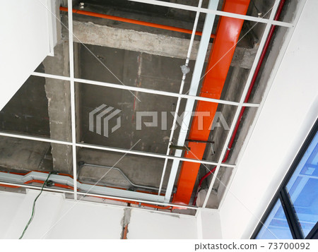 KUALA LUMPUR, MALAYSIA -JULY 24 2020: The suspended ceiling, electrical wiring, cabling and mechanical equipment under installation. It is hanging at the floor soffit. Cover by ceiling board. KUALA LUMPUR, MALAYSIA -JULY 24 2020: The suspended ceiling, electrical wiring, cabling and mechanical equipment under installation. It is hanging at the floor soffit. Cover by ceiling board. 73700092