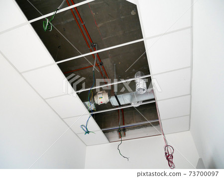 KUALA LUMPUR, MALAYSIA -JULY 24 2020: The suspended ceiling, electrical wiring, cabling and mechanical equipment under installation. It is hanging at the floor soffit. Cover by ceiling board. KUALA LUMPUR, MALAYSIA -JULY 24 2020: The suspended ceiling, electrical wiring, cabling and mechanical equipment under installation. It is hanging at the floor soffit. Cover by ceiling board. 73700097