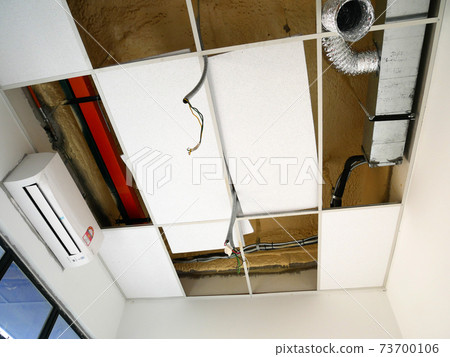 KUALA LUMPUR, MALAYSIA -JULY 24 2020: The suspended ceiling, electrical wiring, cabling and mechanical equipment under installation.  It is hanging at the floor soffit. Cover by ceiling board.  73700106