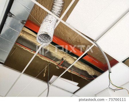 KUALA LUMPUR, MALAYSIA -JULY 24 2020: The suspended ceiling, electrical wiring, cabling and mechanical equipment under installation. It is hanging at the floor soffit. Cover by ceiling board. KUALA LUMPUR, MALAYSIA -JULY 24 2020: The suspended ceiling, electrical wiring, cabling and mechanical equipment under installation. It is hanging at the floor soffit. Cover by ceiling board. 73700111