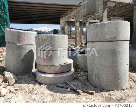 KUALA LUMPUR, MALAYSIA -MARCH 2, 2020: Circular shape precast concrete manhole stacked at the construction site. KUALA LUMPUR, MALAYSIA -MARCH 2, 2020: Circular shape precast concrete manhole stacked at the construction site. 73700212