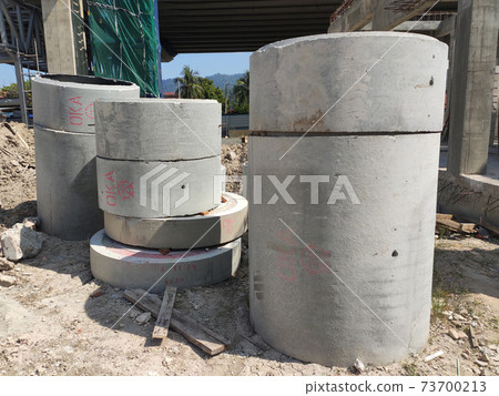 KUALA LUMPUR, MALAYSIA -MARCH 2, 2020: Circular shape precast concrete manhole stacked at the construction site. KUALA LUMPUR, MALAYSIA -MARCH 2, 2020: Circular shape precast concrete manhole stacked at the construction site. 73700213