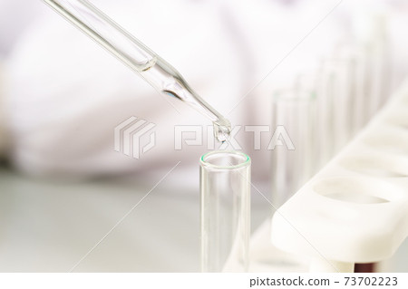Scientist analyzing a blood sample on tray in laboratory 73702223